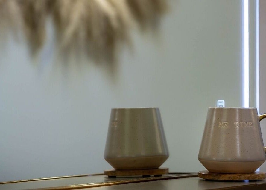 Elegant ceramic mug with 'ME TIME' text on a reflective surface at Utopia Hair Co, Clifton, England, GB.