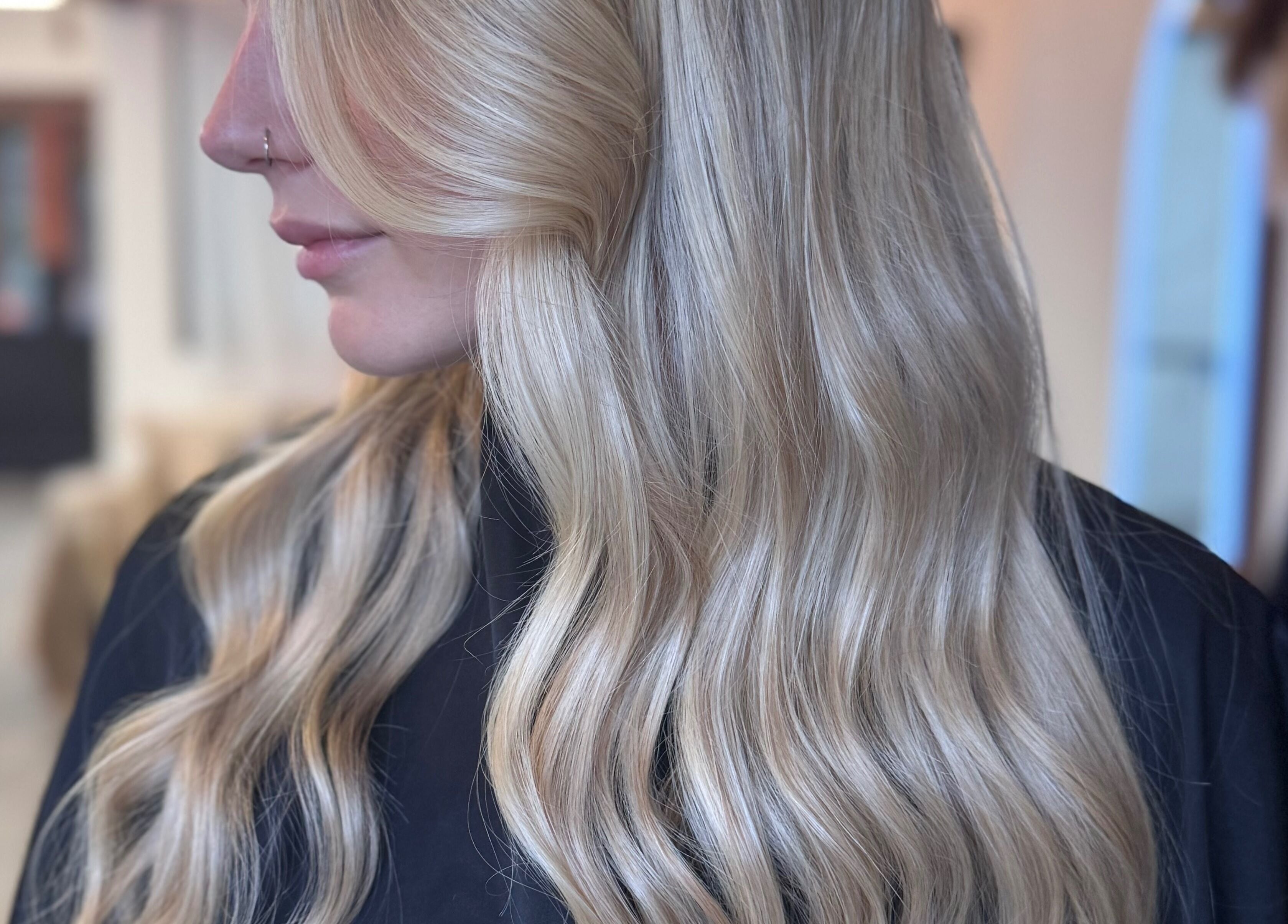 Sleek blonde hair styled at Utopia Hair Co, Clifton, England, GB. Showcasing soft waves and shine.
