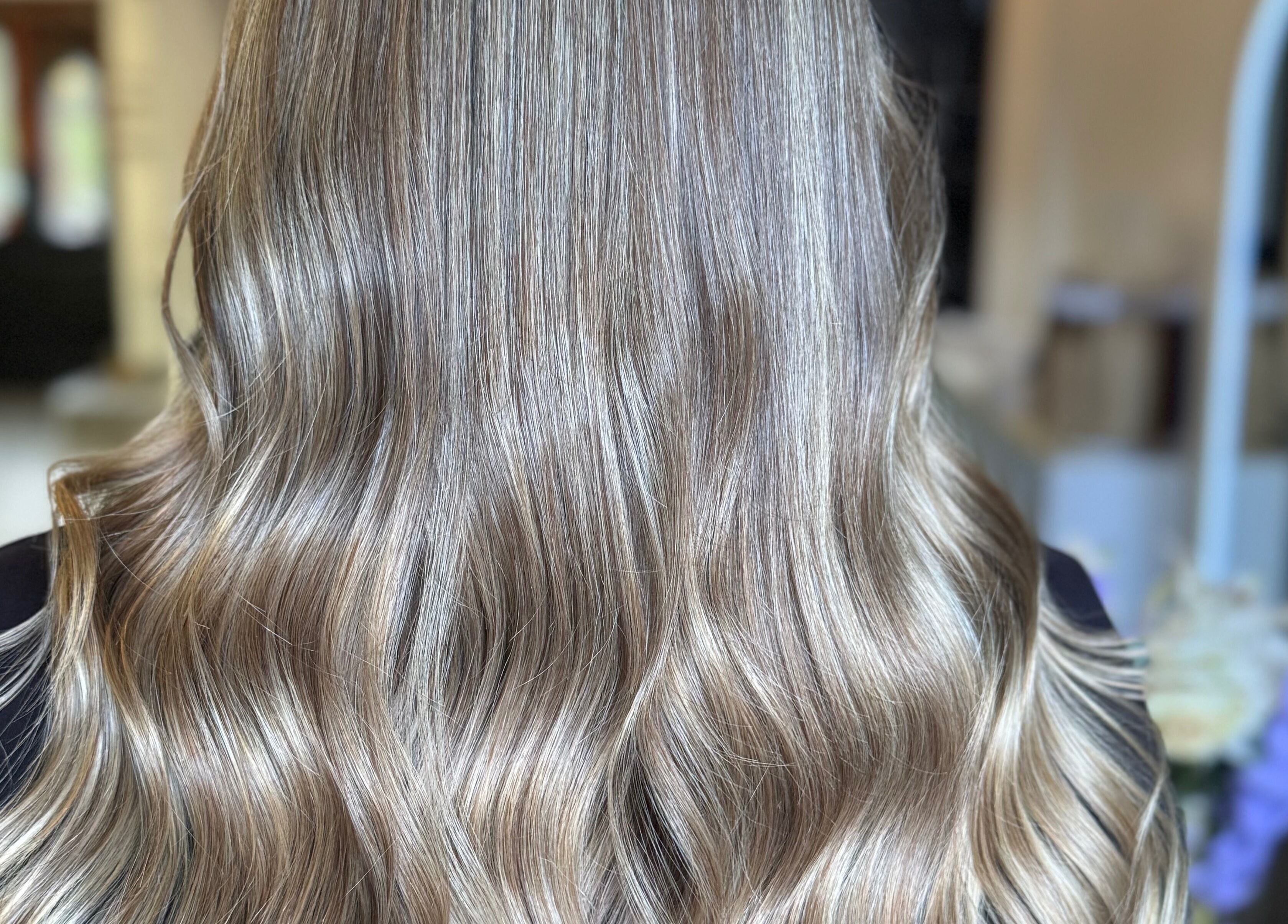 Elegant wavy blonde hair styled at Utopia Hair Co, Clifton, England, GB for a stunning look.