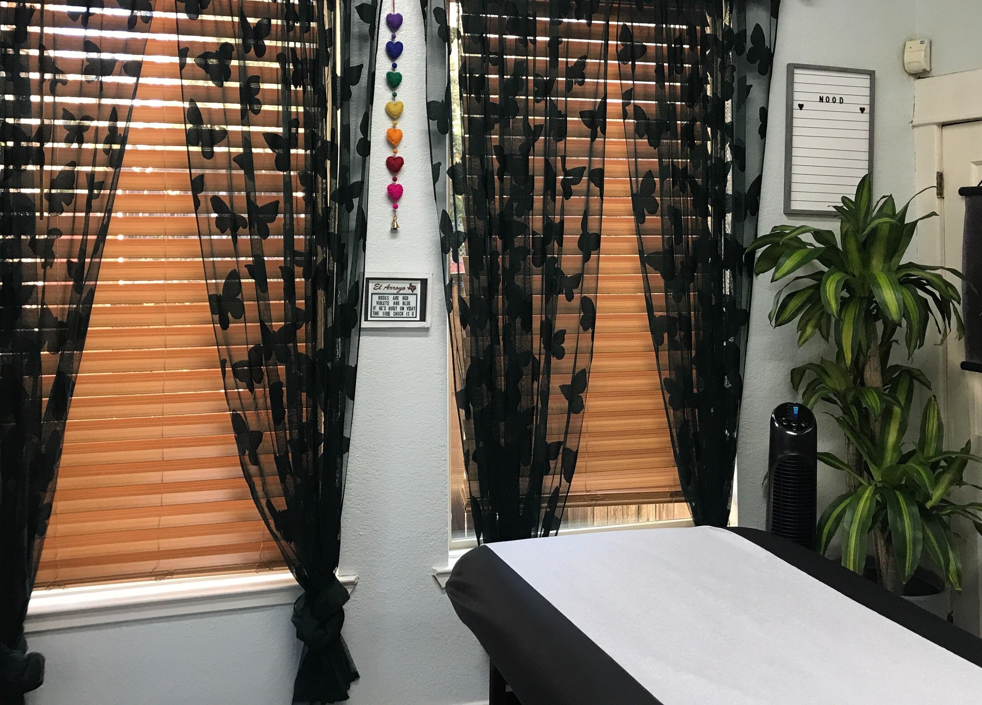 Tranquil treatment room at Nood Wax & Sugar ATX, Austin, Texas, with black floral curtains and a cozy ambiance.