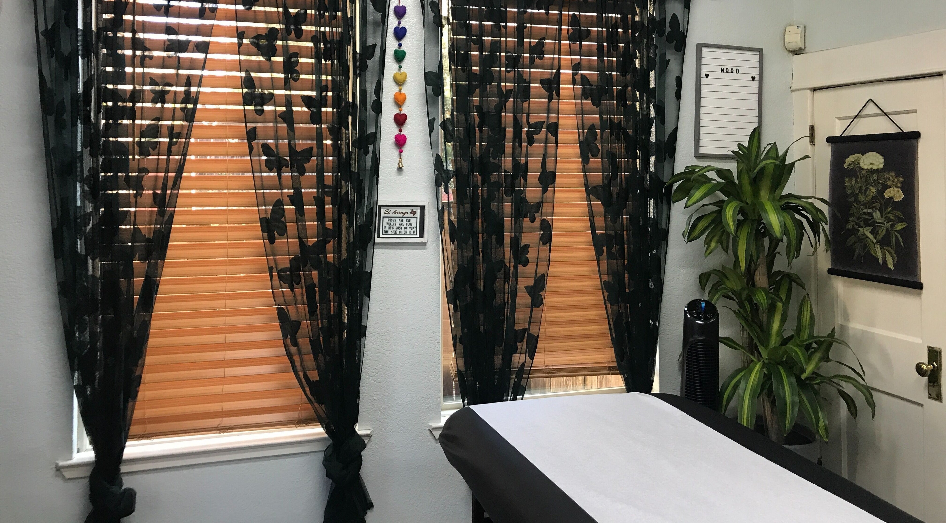Tranquil treatment room at Nood Wax & Sugar ATX, Austin, Texas, with black floral curtains and a cozy ambiance.