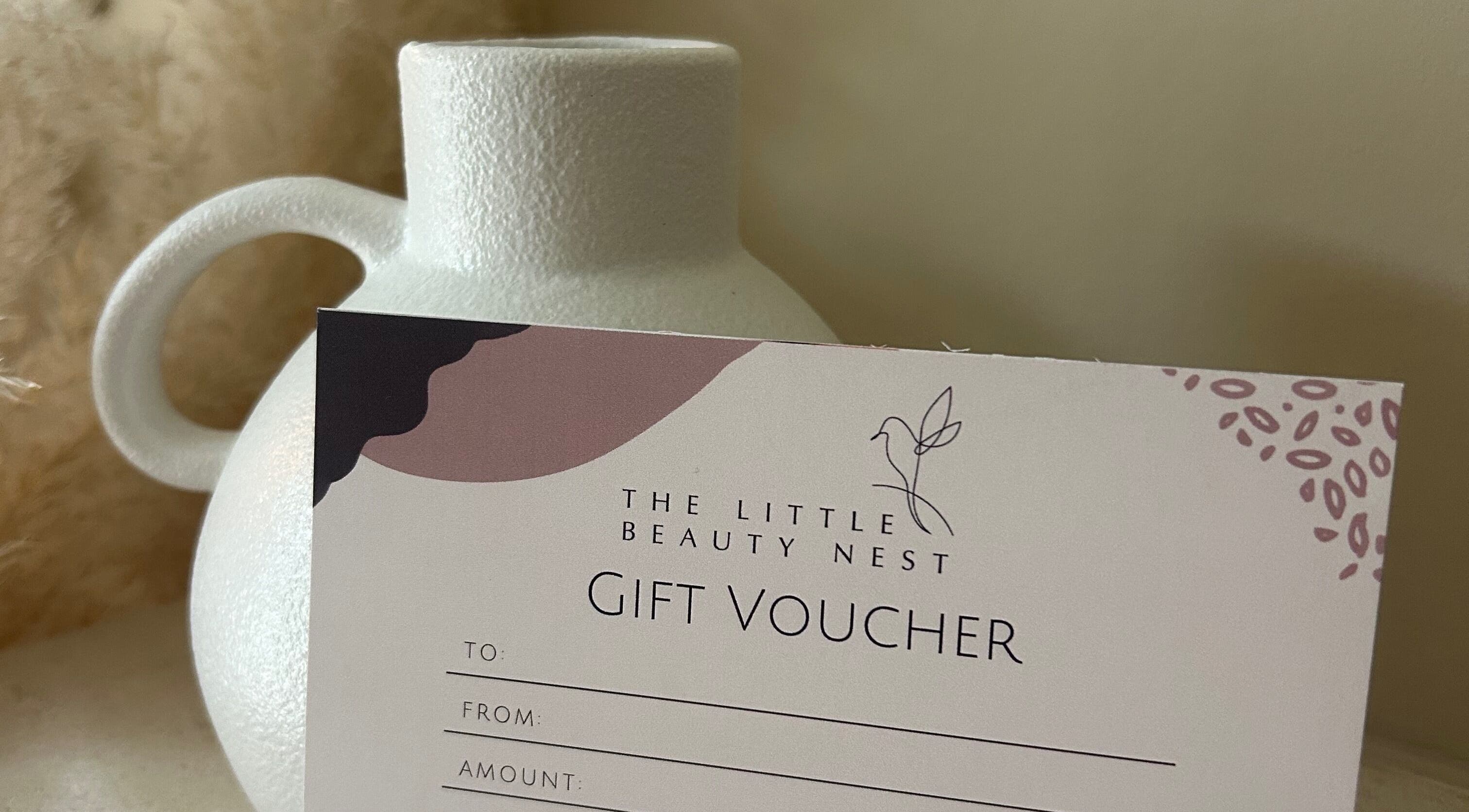 Gift voucher for The Little Beauty Nest, Ilkeston, England, GB beautifully presented beside a white ceramic vase.