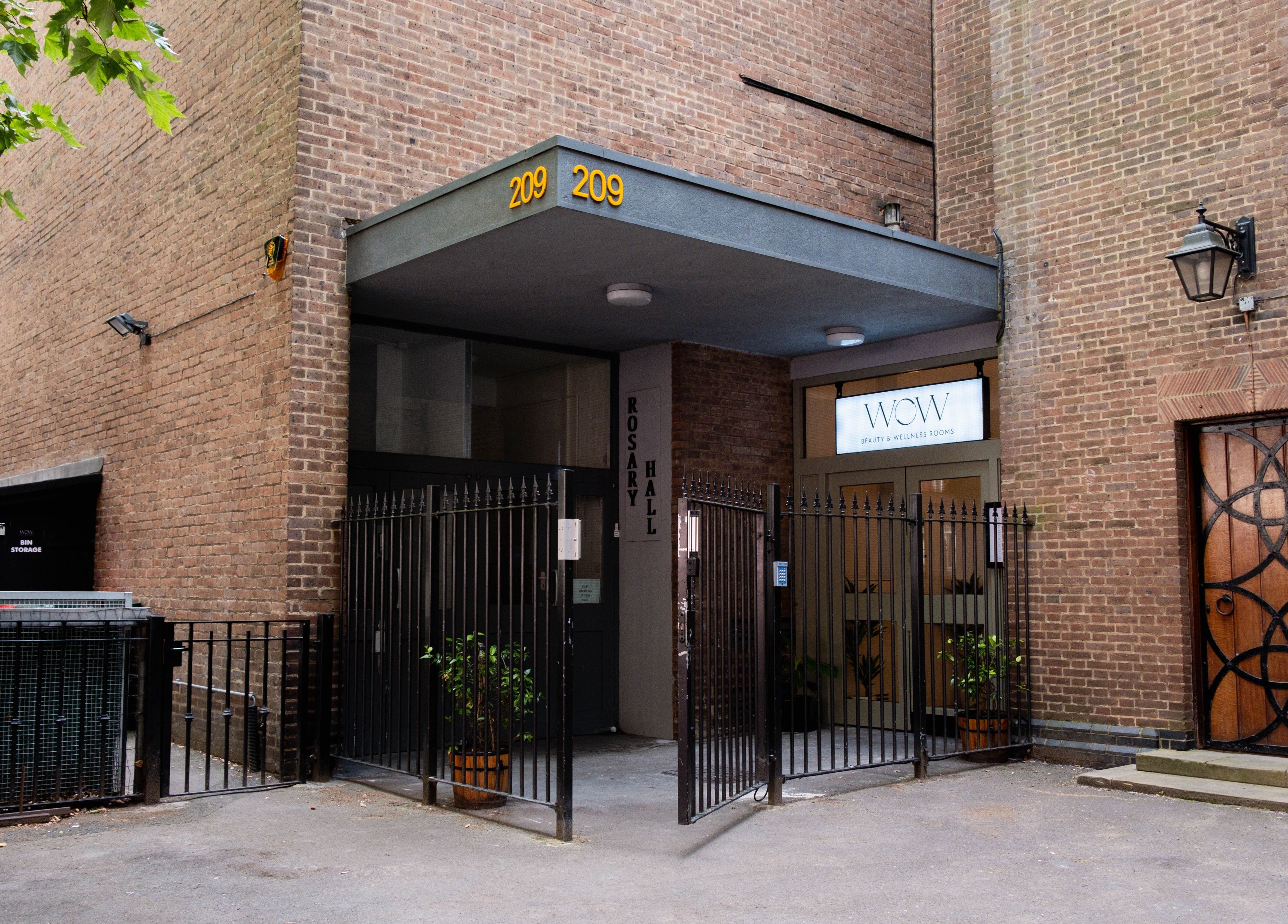 Entrance to O!GLOW-ON: byAudrey.ldn in London, England, GB framed by brick walls and a welcoming gate.