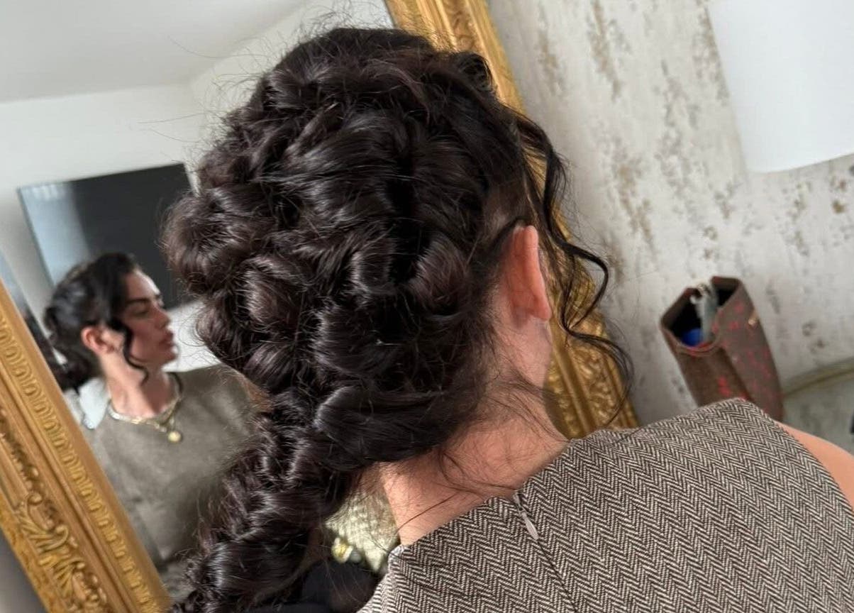 Woman with an elegant updo hairstyle at By Brown, Hetton-le-hole, England, GB, reflected in a mirror.