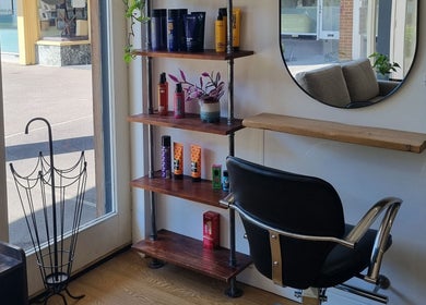 Modern salon corner at D&G Hairdressing, Chandler's Ford, England, with a sleek chair, mirror, and products.