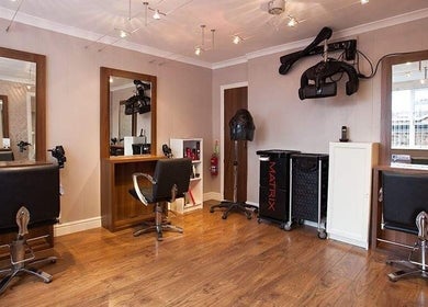 Stylish interior of Status Hair Design salon in York, England, GB featuring modern hairdressing stations.