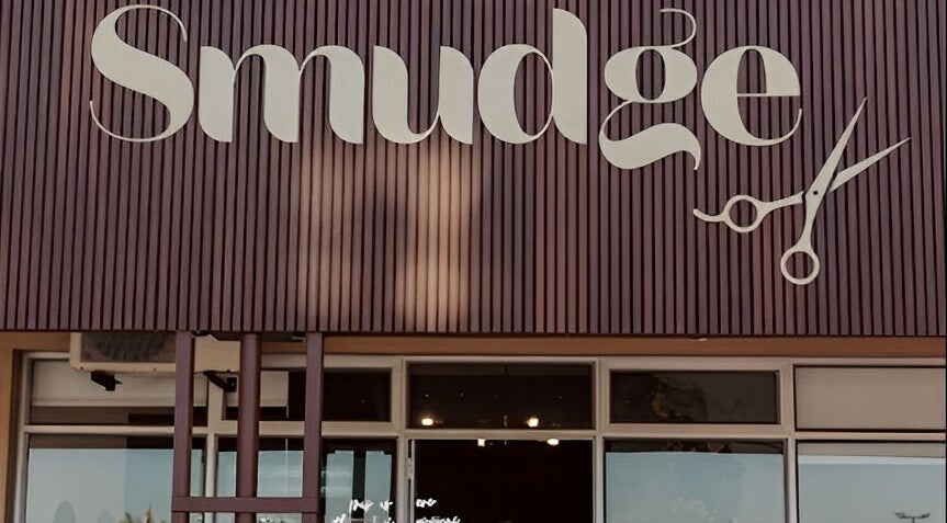 Smudge salon entrance in Stellenbosch, Western Cape, ZA, showcasing elegant sign and scissor logo.