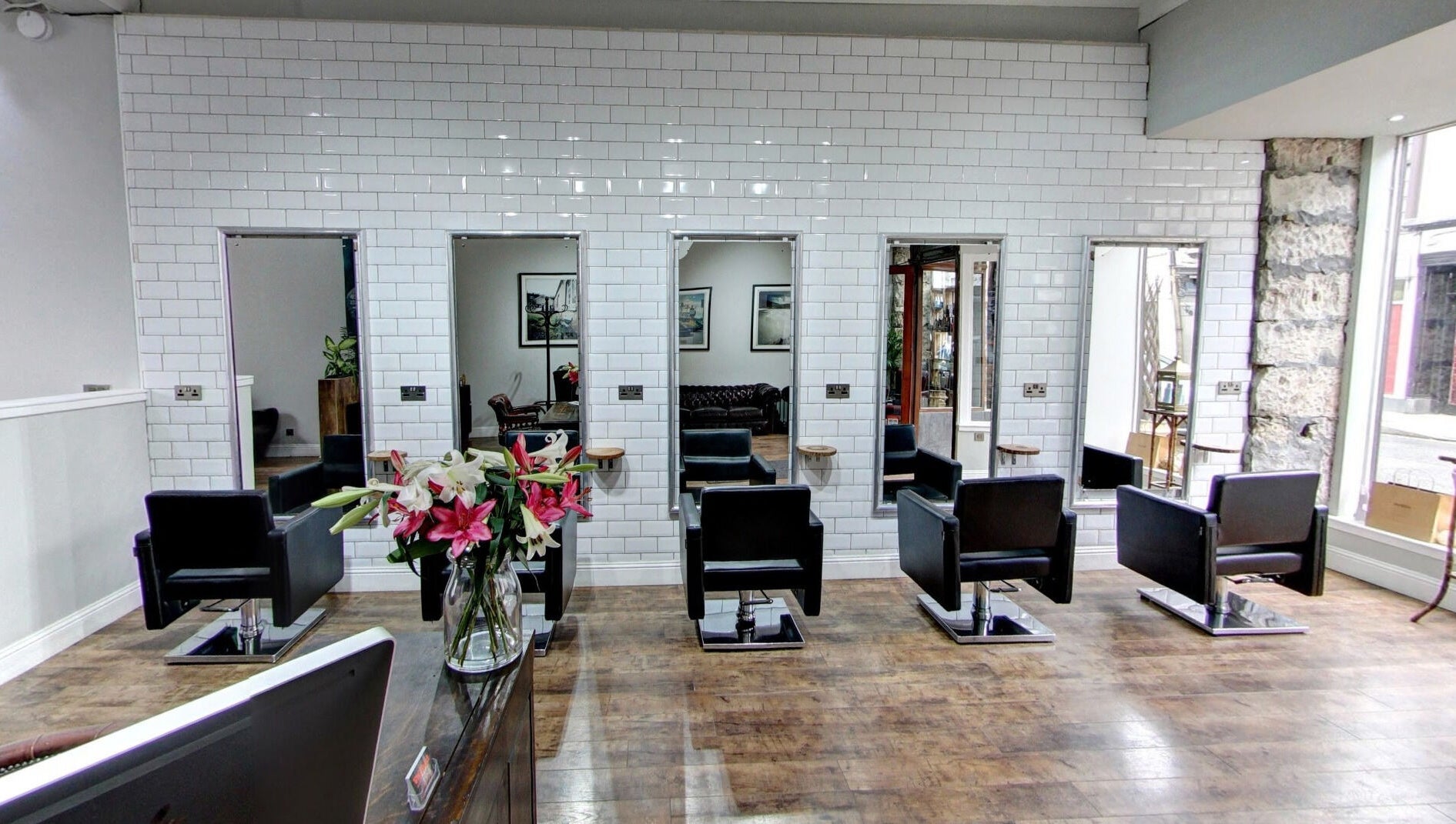 Modern salon interior at Claire @ Vollood in Dunfermline, Scotland, GB with stylish black chairs and large mirrors.