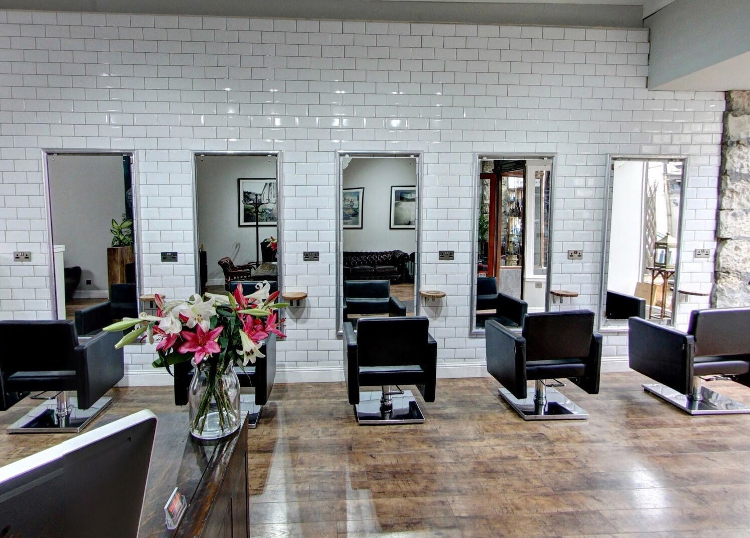 Modern salon interior at Claire @ Vollood in Dunfermline, Scotland, GB with stylish black chairs and large mirrors.