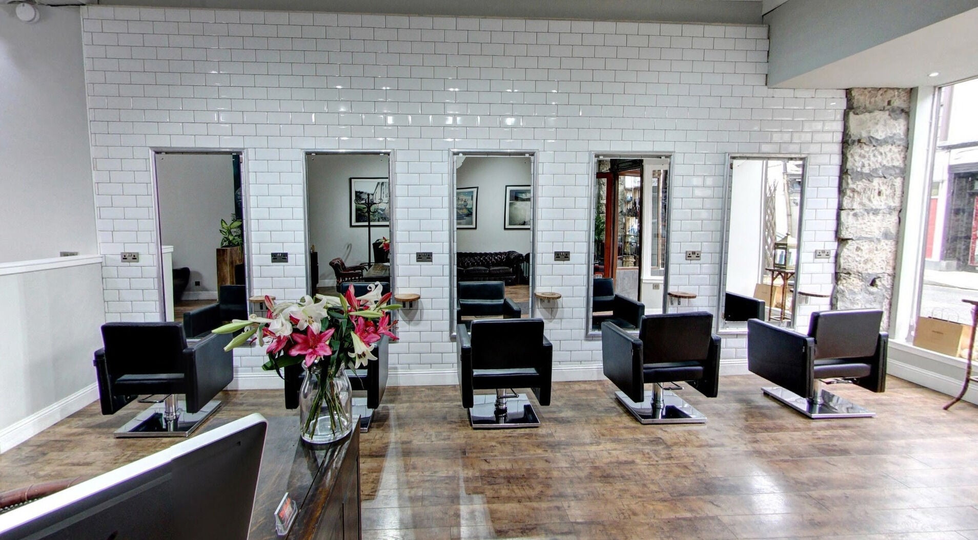 Modern salon interior at Claire @ Vollood in Dunfermline, Scotland, GB with stylish black chairs and large mirrors.
