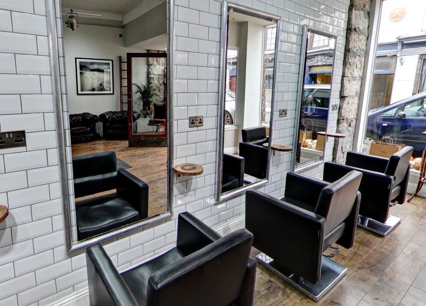 Modern salon interior at Claire @ Vollood, Dunfermline, Scotland, GB with sleek black chairs and large mirrors.