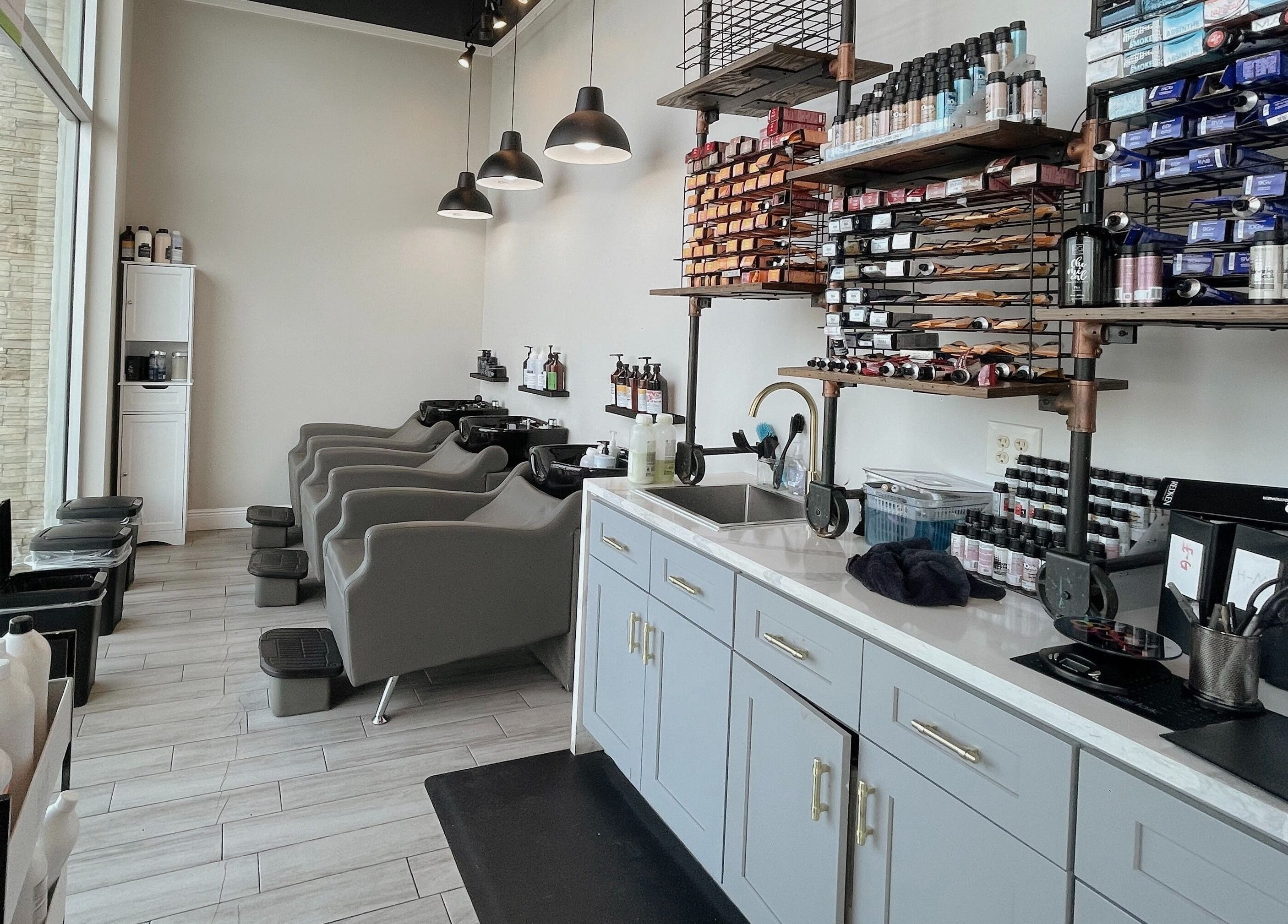 Modern salon interior at Tipsy Salonbar Naples, Naples, Florida, US, featuring sleek hair wash stations and product shelves.