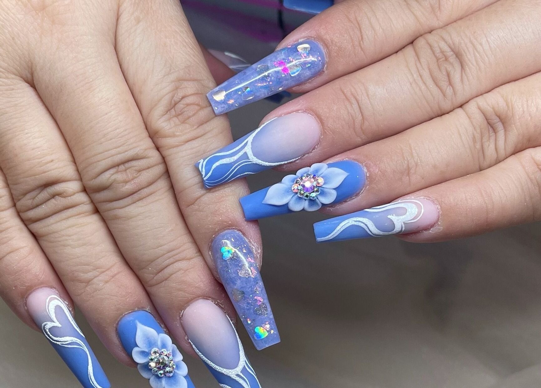Intricate blue and white nail art with floral design at Tipsy Salonbar Naples, Naples, Florida, US.