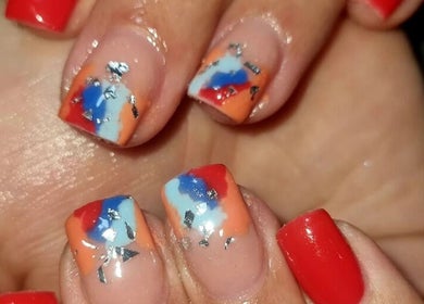 Vibrant nail art at Beautello in Polokwane, Limpopo, ZA, showcasing red, blue, and orange designs.