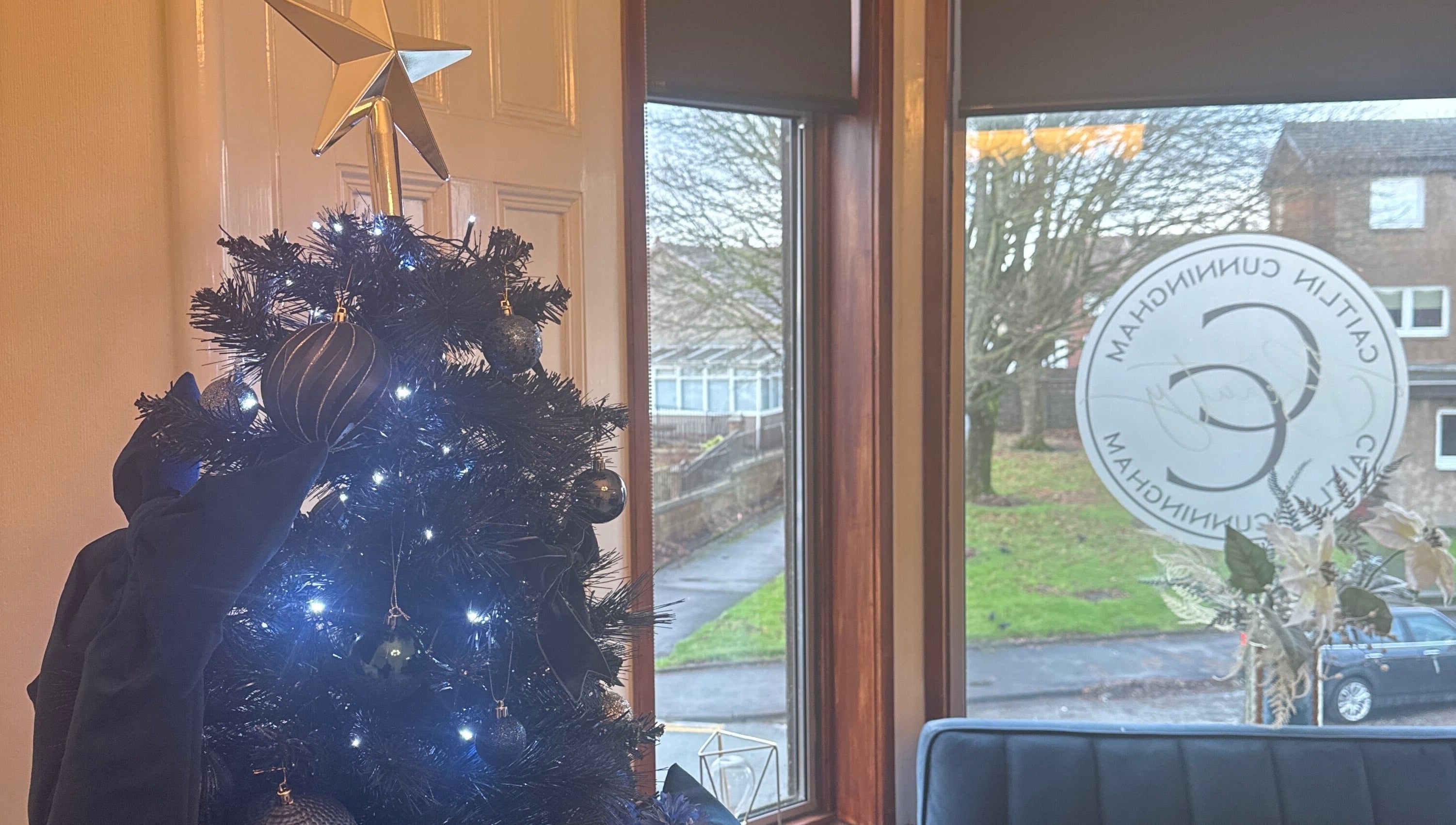 Festive decor at CCB Studios, Stenhousemuir, Scotland, GB with a lit Christmas tree by the window.