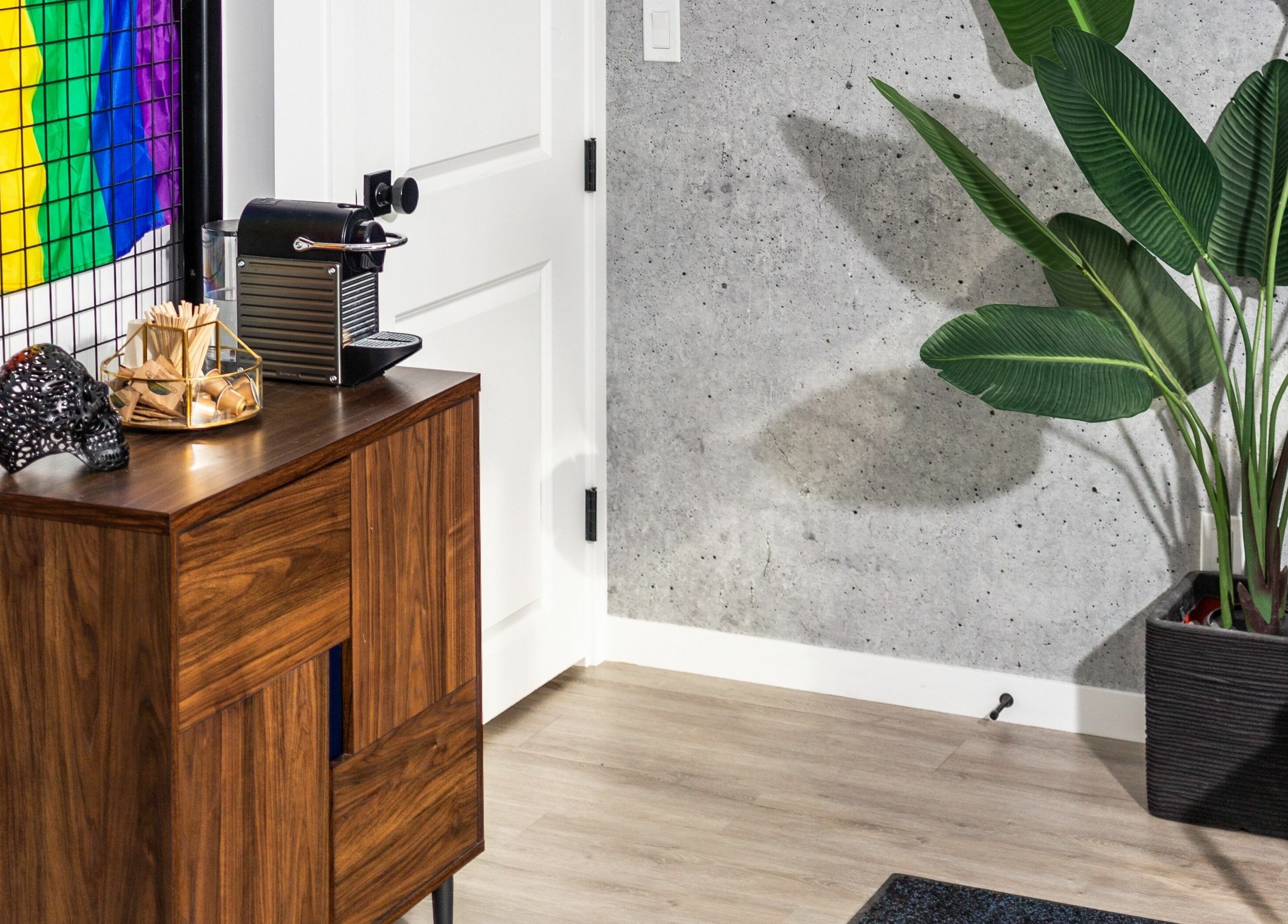 Modern corner at Rebel X, Calgary, Alberta, CA featuring a wooden cabinet and greenery for a stylish atmosphere.