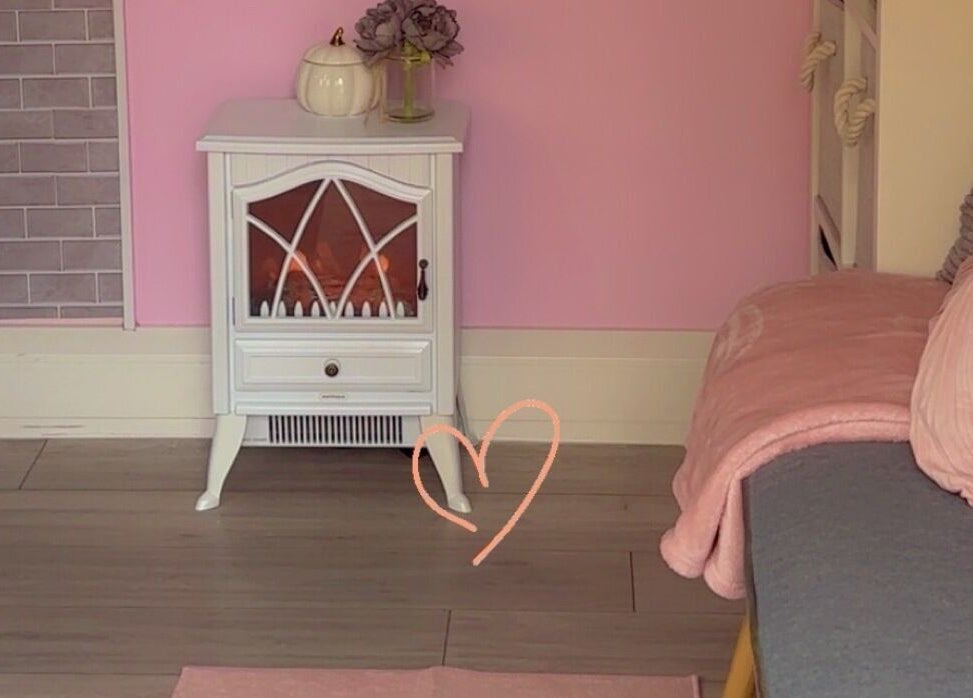Charming pink corner at Kayotic Nails, Andover, England, GB with a decorative heater and soft seating.
