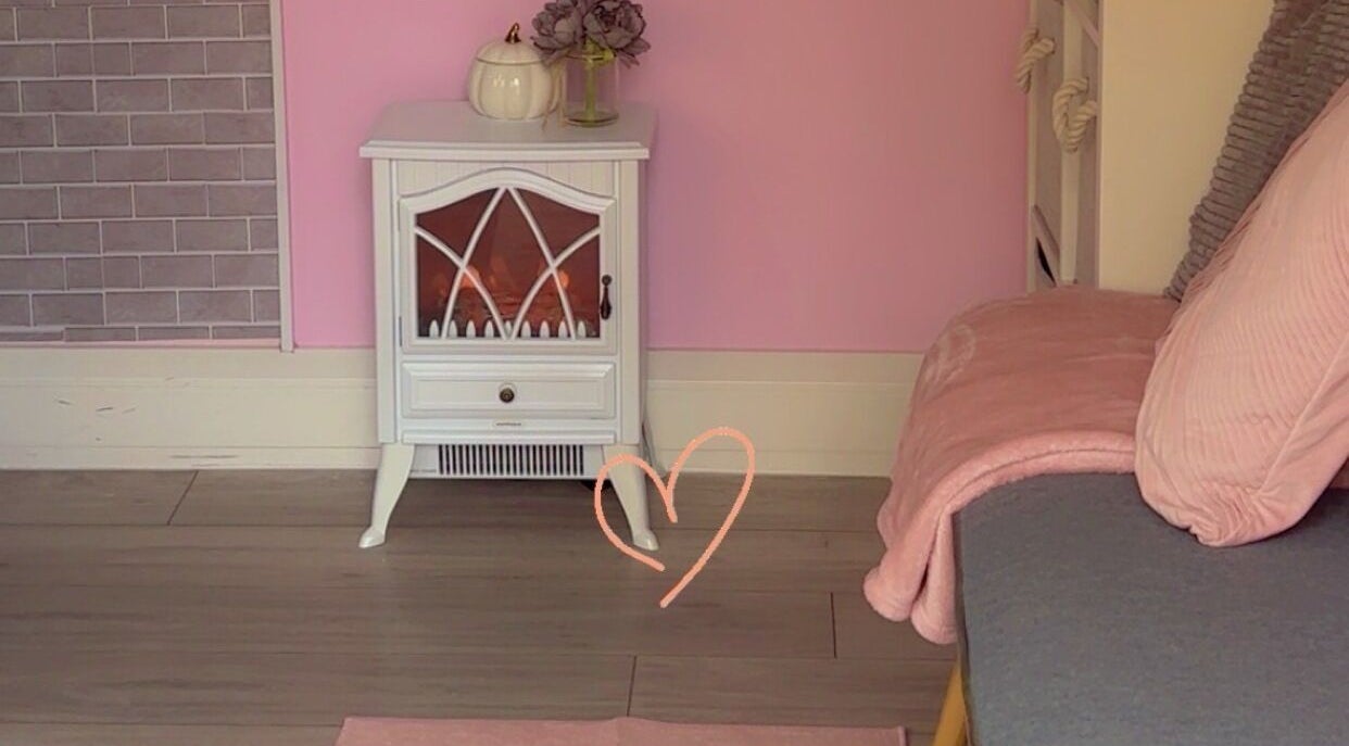 Charming pink corner at Kayotic Nails, Andover, England, GB with a decorative heater and soft seating.