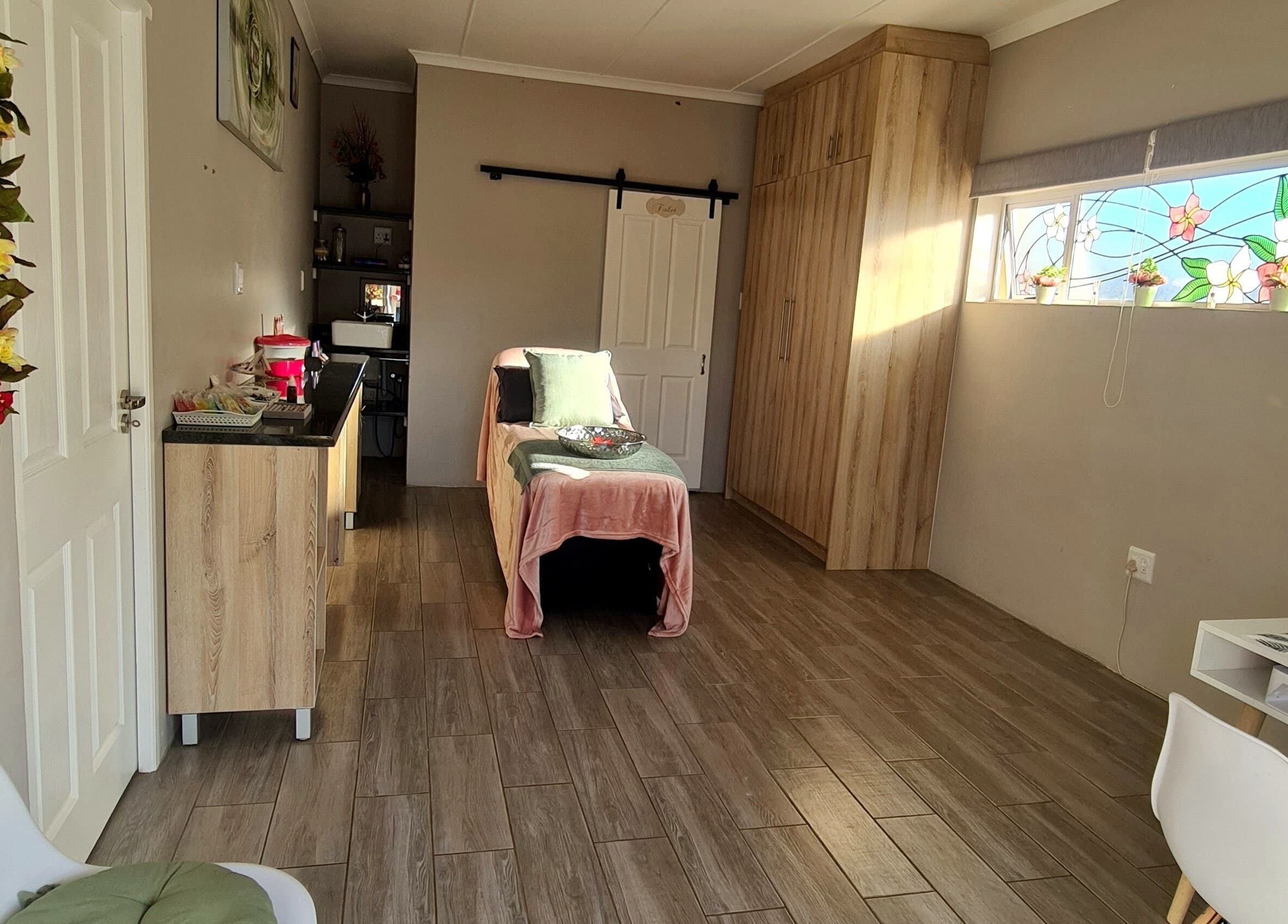 Relaxing spa room at Beauty Secrets in Jeffreys Bay, Eastern Cape, ZA with a massage table and floral decor.