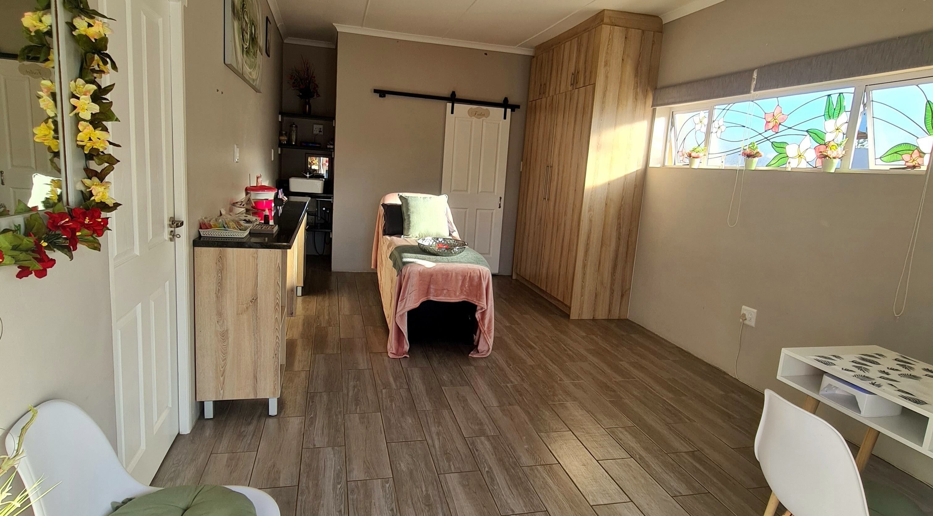 Relaxing spa room at Beauty Secrets in Jeffreys Bay, Eastern Cape, ZA with a massage table and floral decor.