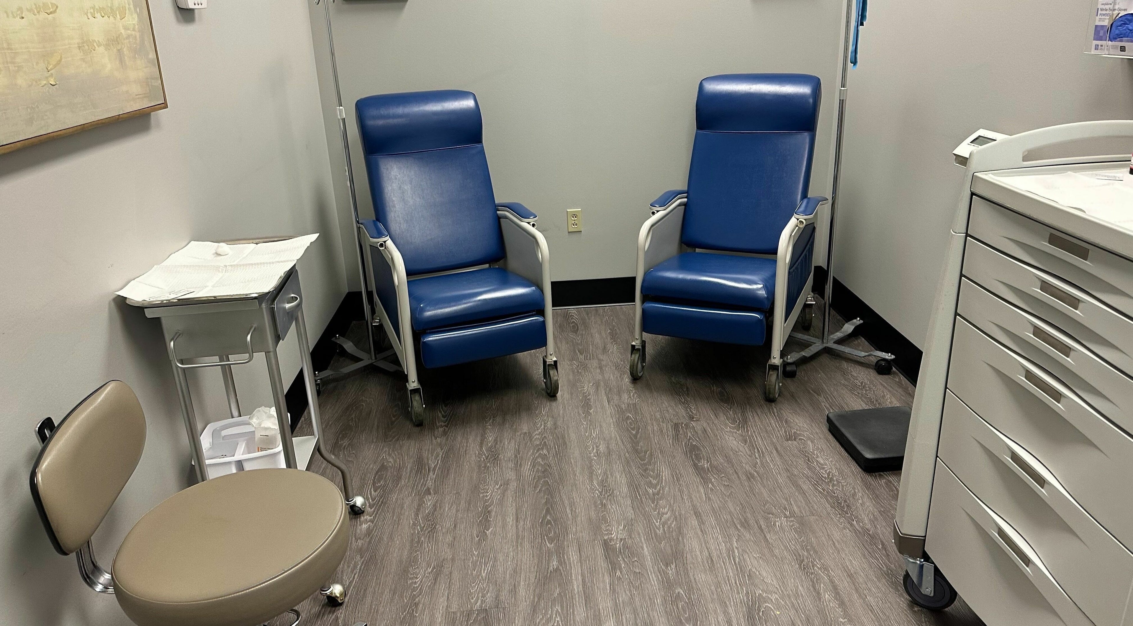 Calm treatment room at Healthy Solutions MD in Mentor, Ohio, US, featuring comfortable blue chairs and wooden floors.