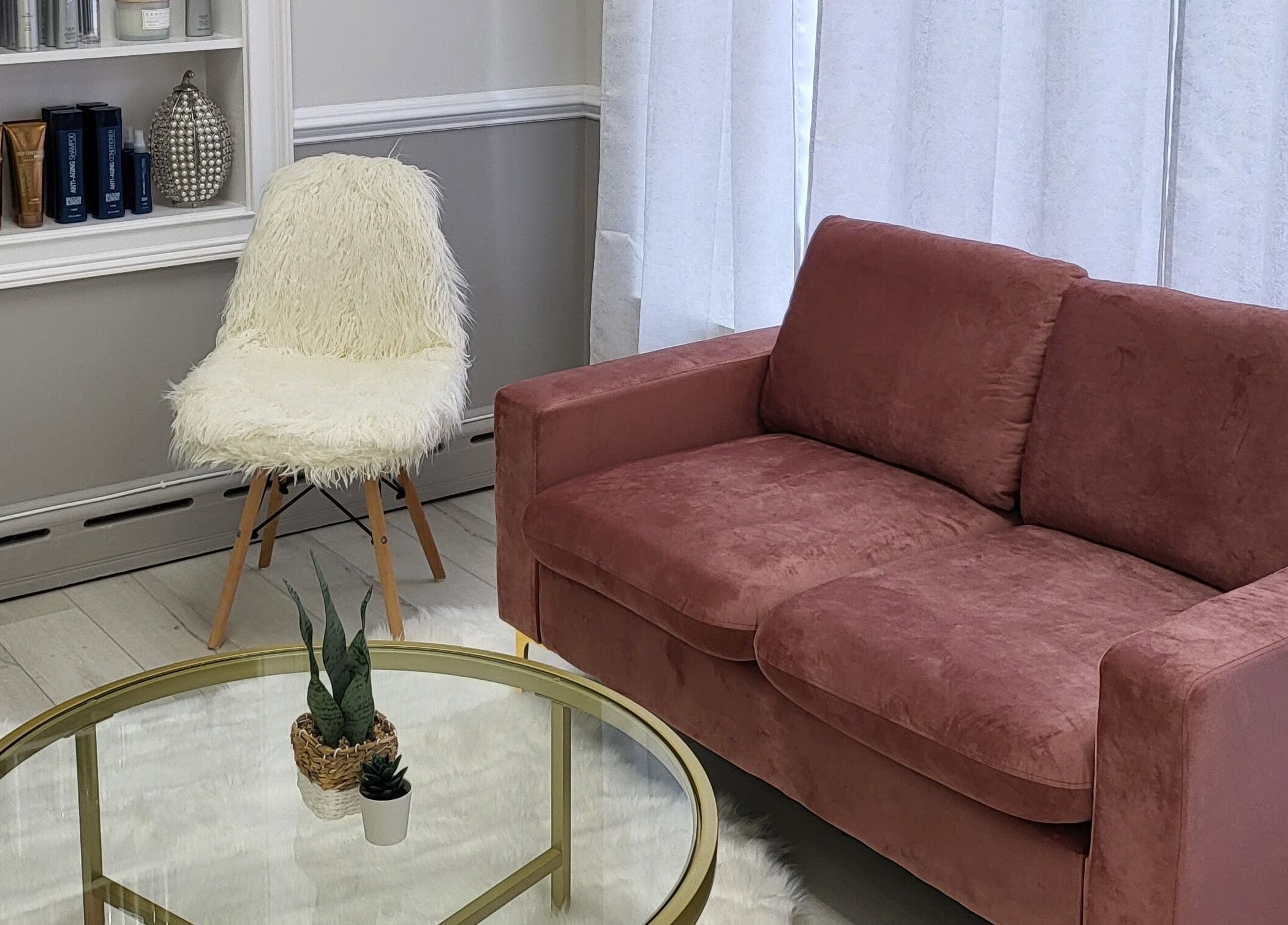 Stylish waiting area in JQ The Salon, Stanhope, New Jersey, US with a velvet couch and plush chair.