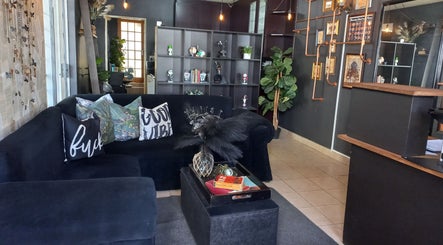 Cozy lounge at Dare to Ink Tattoo Studio, Bloemfontein, Free State, ZA. Black sofa with decor accents.