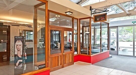 Elegant entrance of Chic Hairdressing, Whanganui, Manawatu-Wanganui, NZ with glass and wooden decor.
