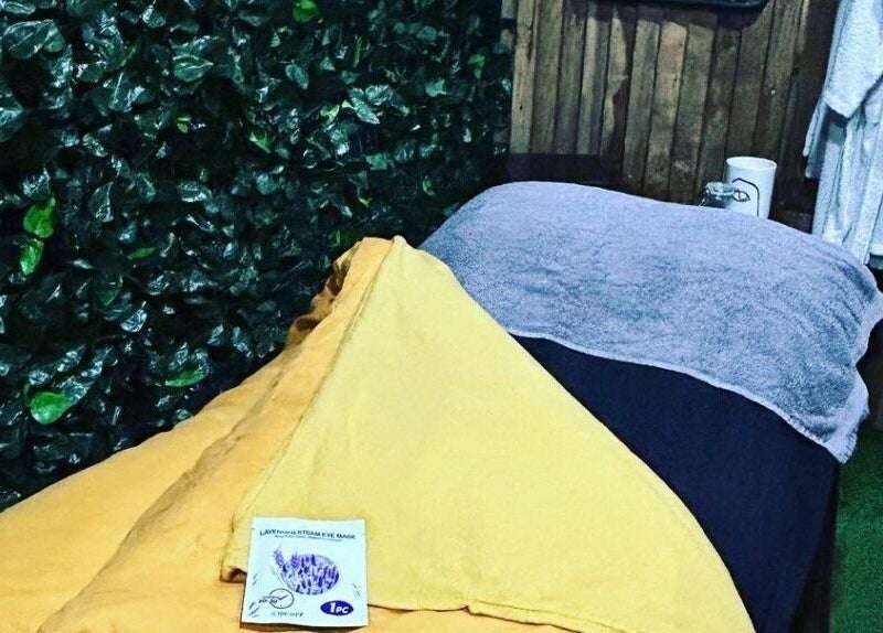 Relaxing spa bed at Lady Muck, Bilston with plush towels and greenery, located in Bilston, Scotland, GB.