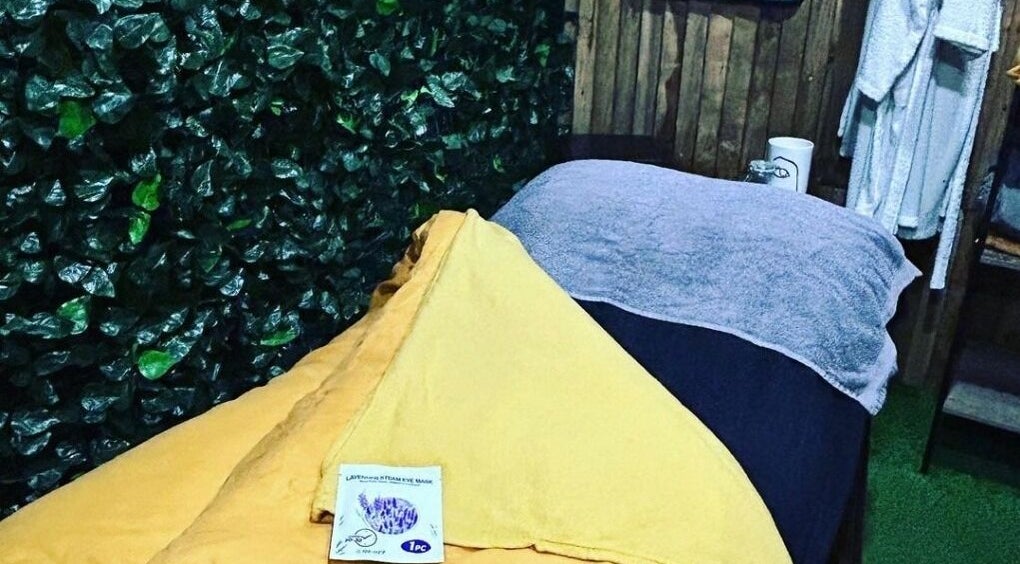 Relaxing spa bed at Lady Muck, Bilston with plush towels and greenery, located in Bilston, Scotland, GB.