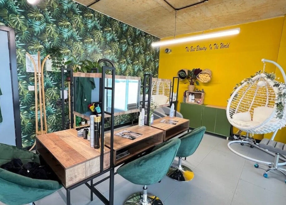 Chic tropical interior of Lily & Jack's Deptford salon, London, England, GB with lush greenery and cozy seating.
