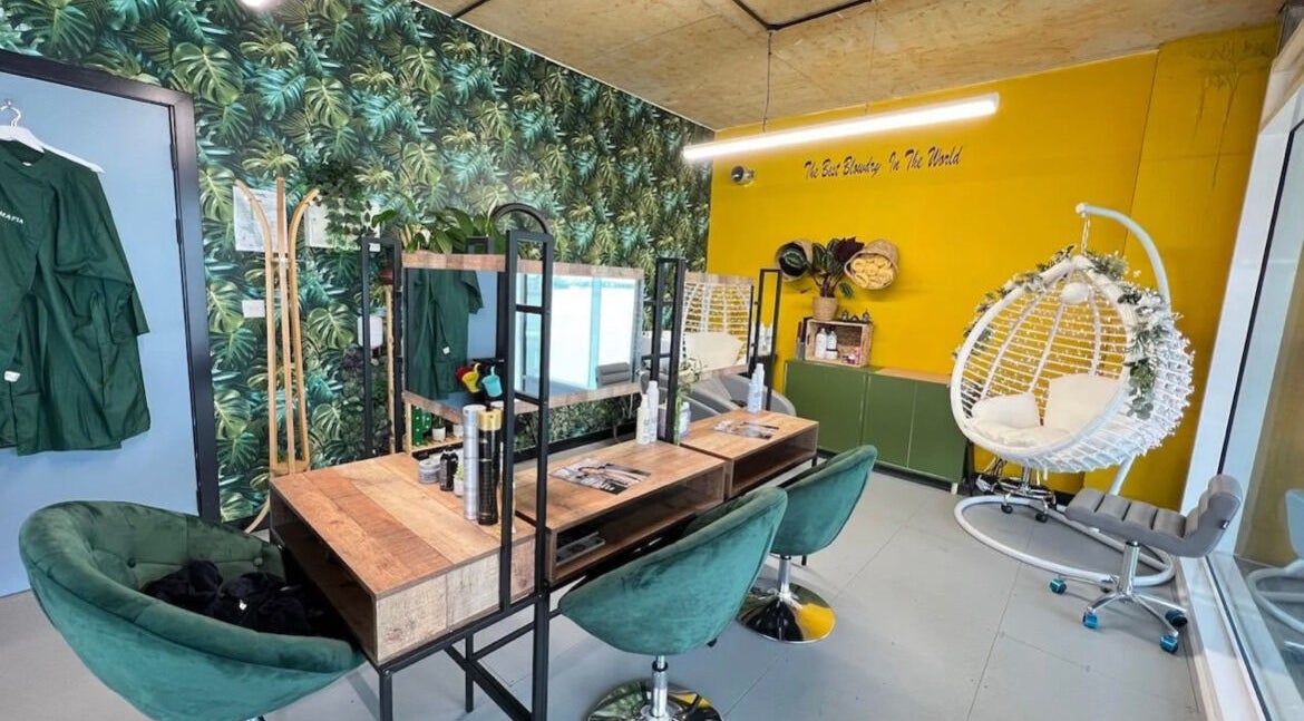 Chic tropical interior of Lily & Jack's Deptford salon, London, England, GB with lush greenery and cozy seating.