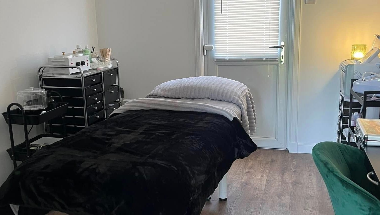 Relaxing therapy room at Beautywell, Addiewell, Scotland, GB with cozy bed and warm lighting.