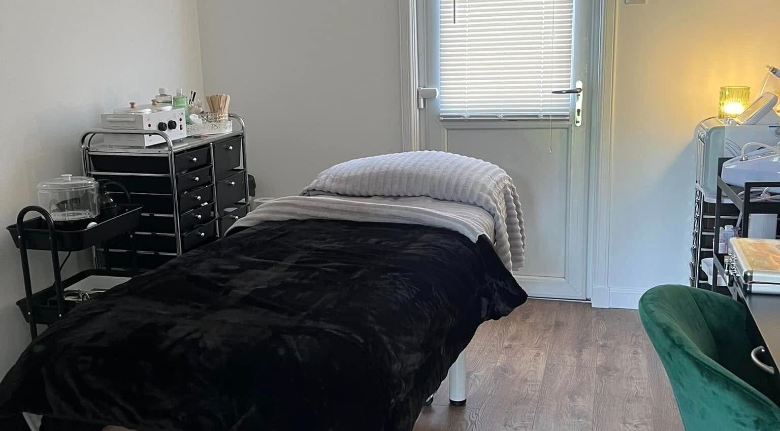 Relaxing therapy room at Beautywell, Addiewell, Scotland, GB with cozy bed and warm lighting.