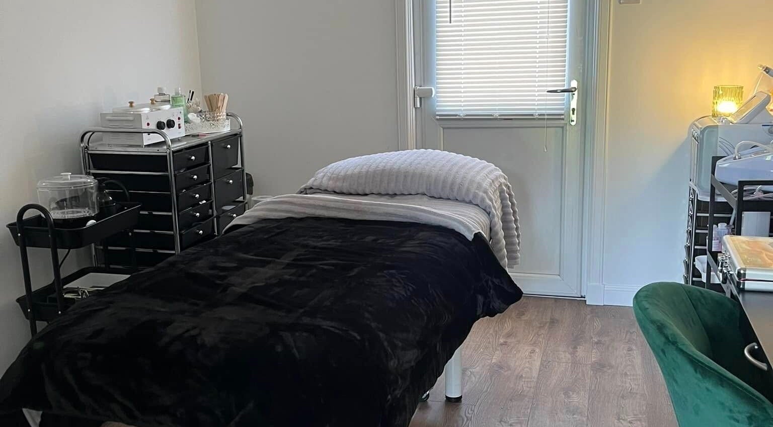 Relaxing therapy room at Beautywell, Addiewell, Scotland, GB with cozy bed and warm lighting.