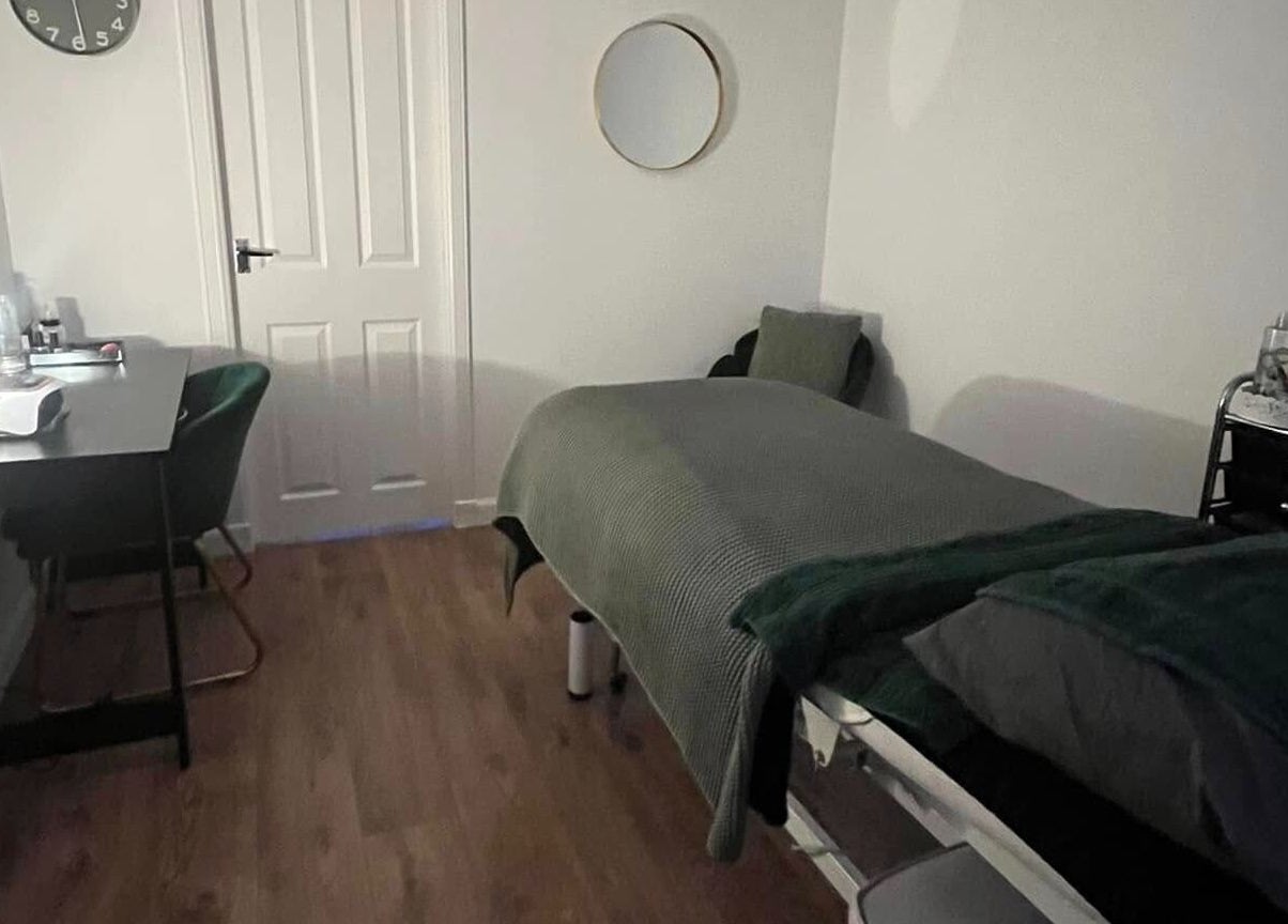 Cozy treatment room at Beautywell, Addiewell, Scotland, GB featuring massage bed and serene decor.
