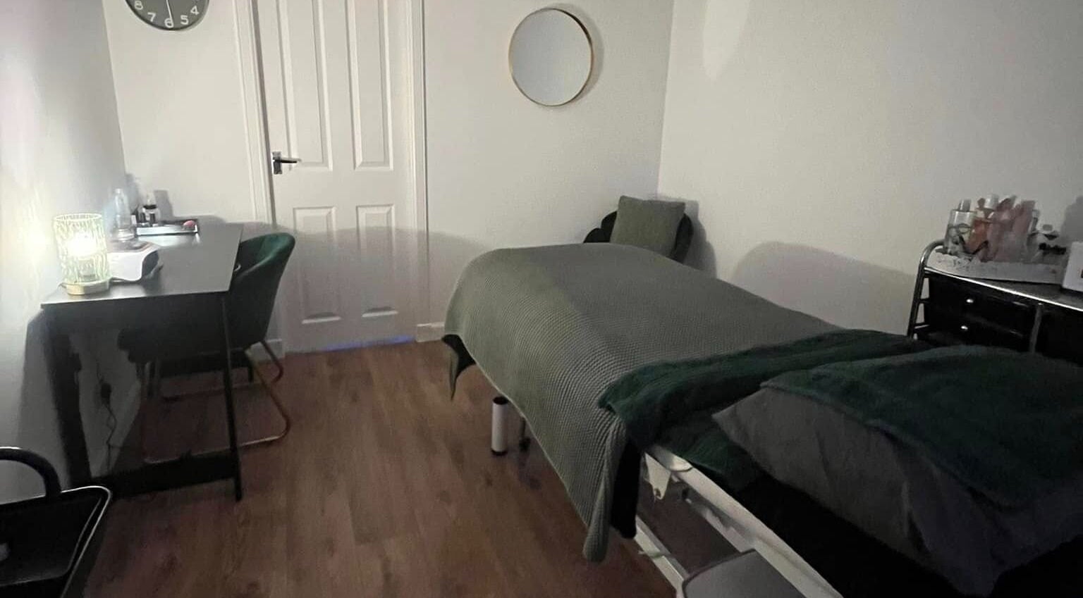 Cozy treatment room at Beautywell, Addiewell, Scotland, GB featuring massage bed and serene decor.