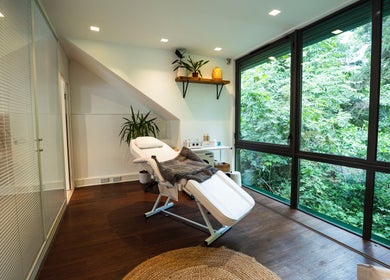 Relaxing treatment room at Somewhere in Queens Park, London, England, GB with lush greenery view.