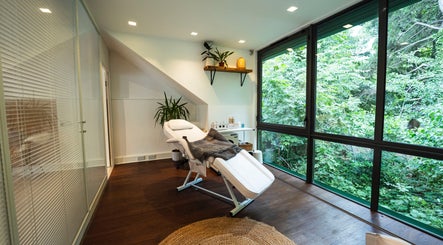 Relaxing treatment room at Somewhere in Queens Park, London, England, GB with lush greenery view.