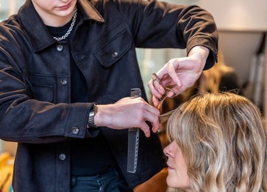 Professional haircut at Somewhere in Queens Park, London, England, GB. Stylist using scissors and comb.