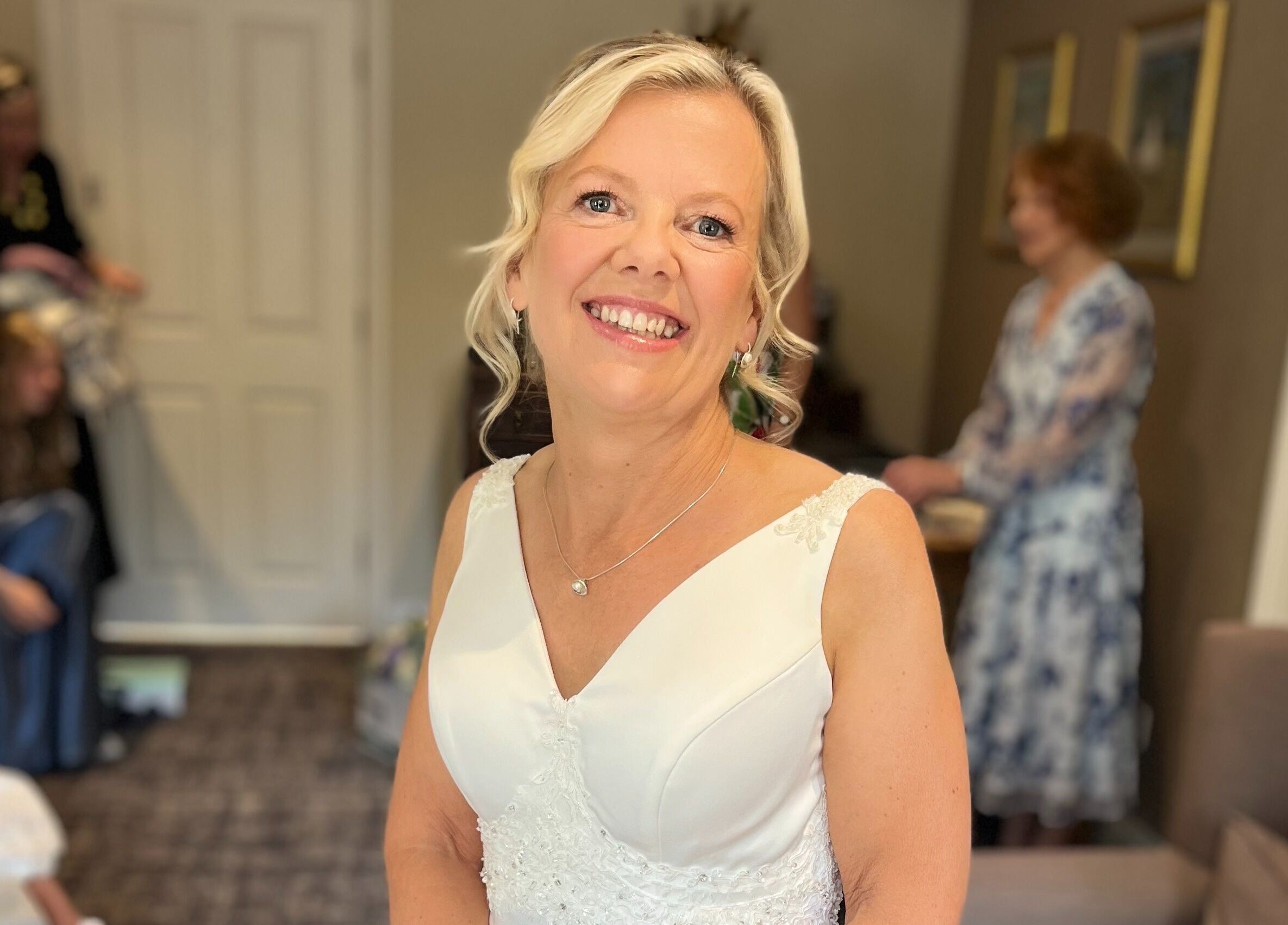 Smiling bride at Hair by Tamiyya, Reading, England. Elegant hairstyle and bridal gown.