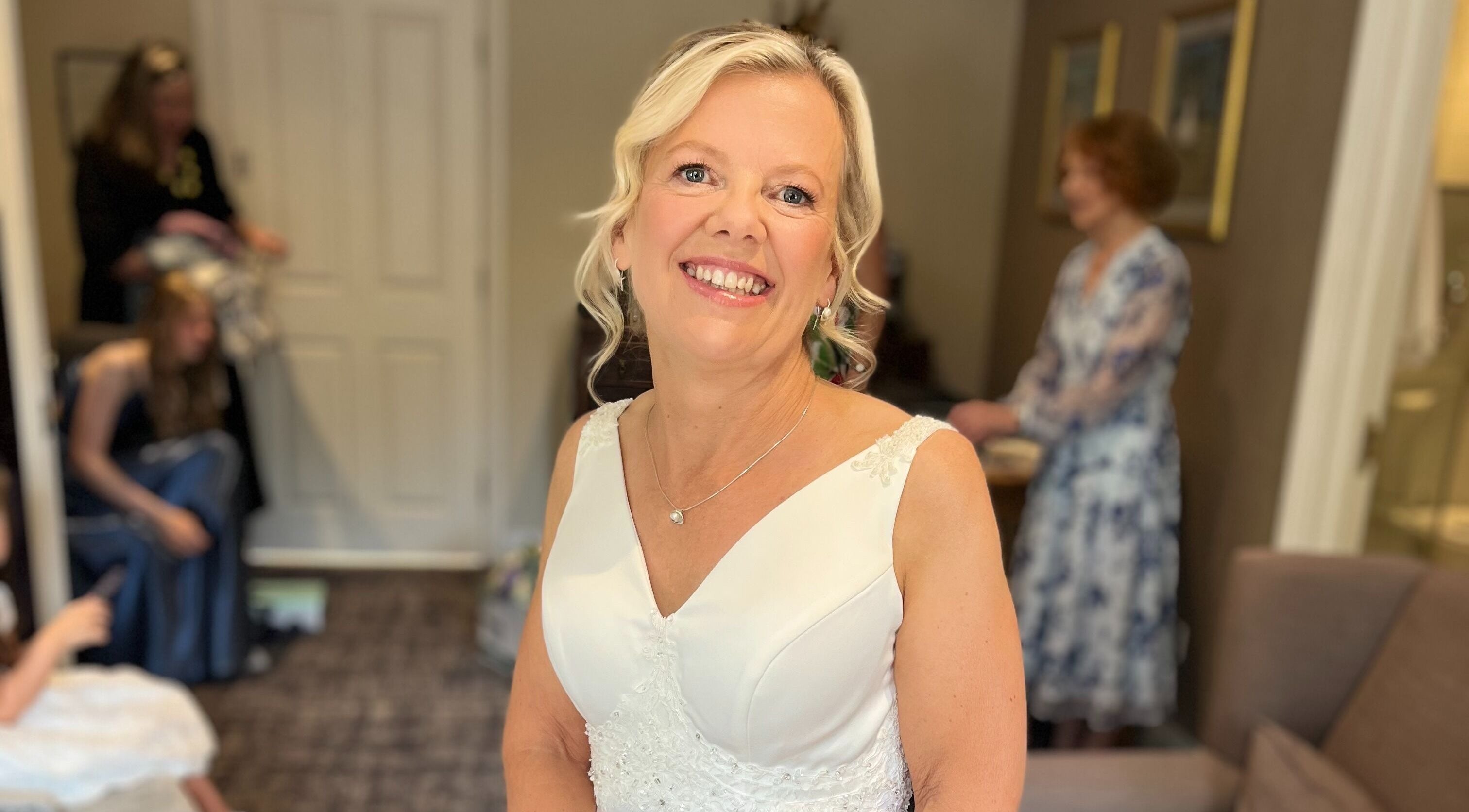 Smiling bride at Hair by Tamiyya, Reading, England. Elegant hairstyle and bridal gown.
