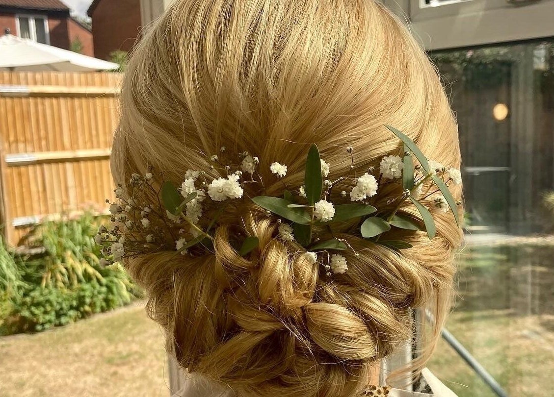 Elegant floral updo hairstyled at Hair by Tamiyya in Reading, England, GB, showcasing delicate flower accents.