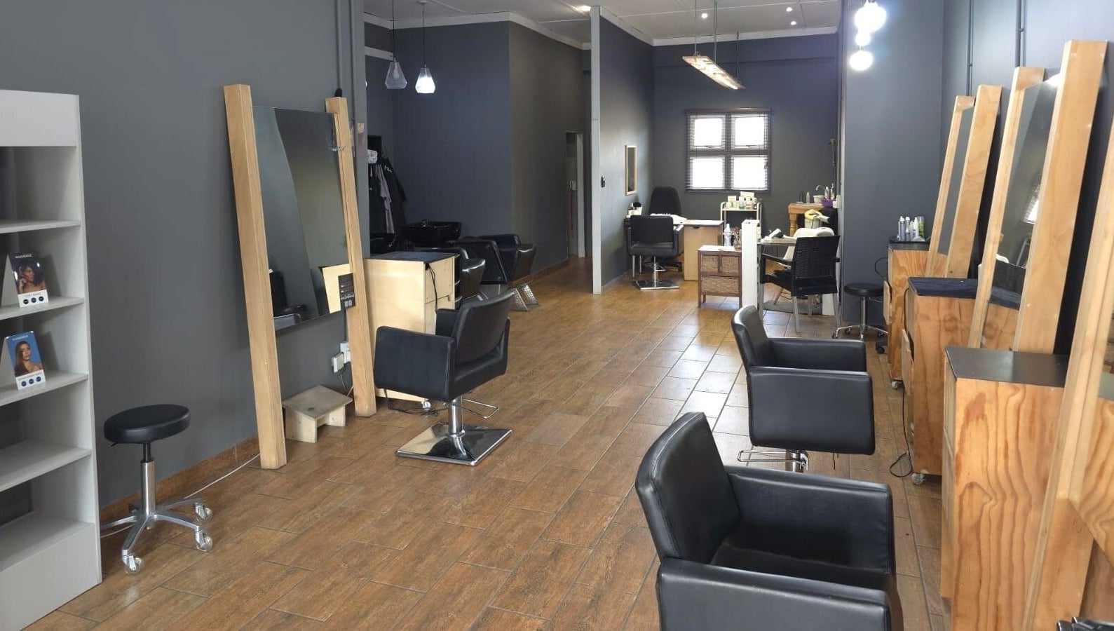 Modern salon interior at Manetain, Pretoria, Gauteng, ZA with sleek black chairs and wooden accents.