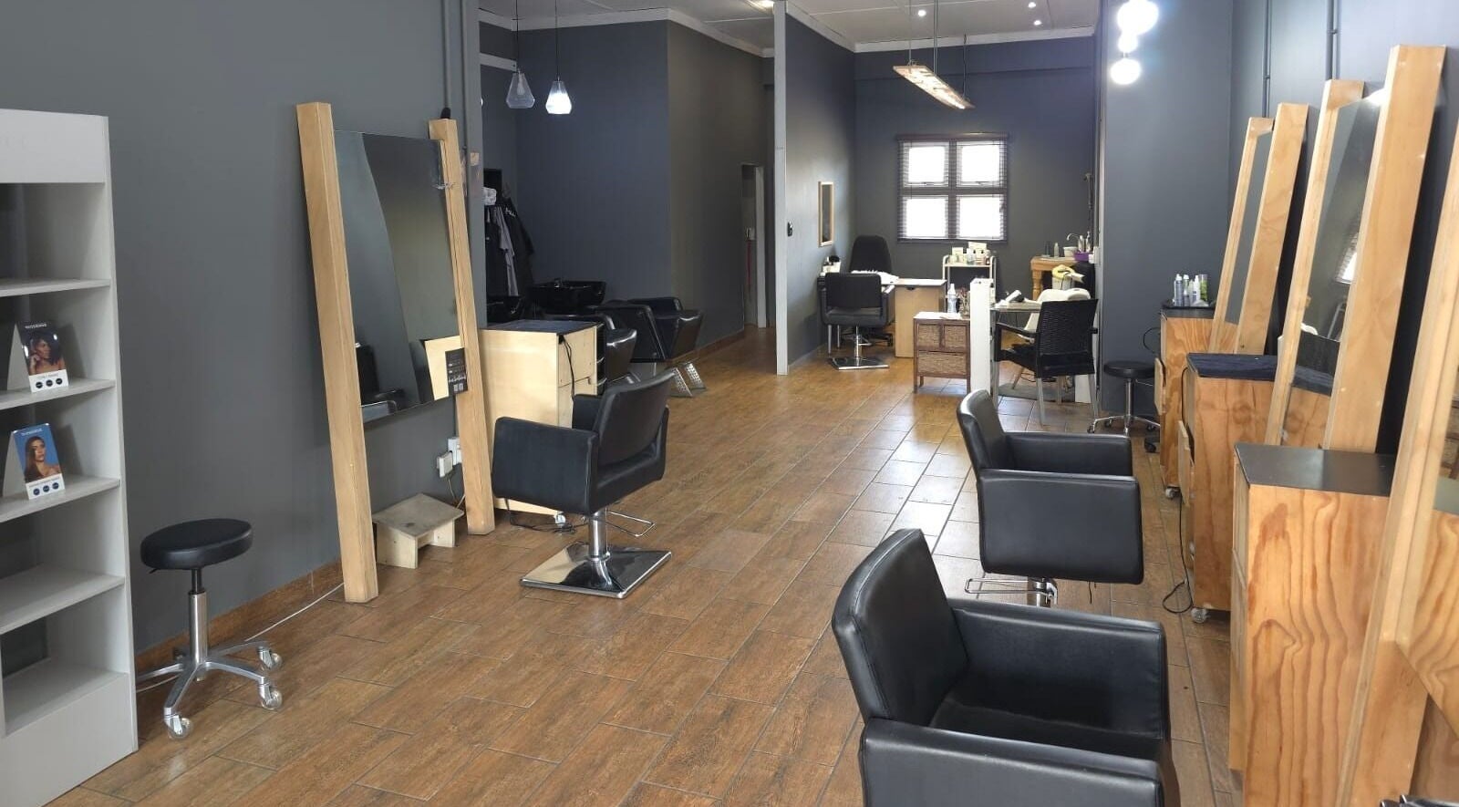 Modern salon interior at Manetain, Pretoria, Gauteng, ZA with sleek black chairs and wooden accents.