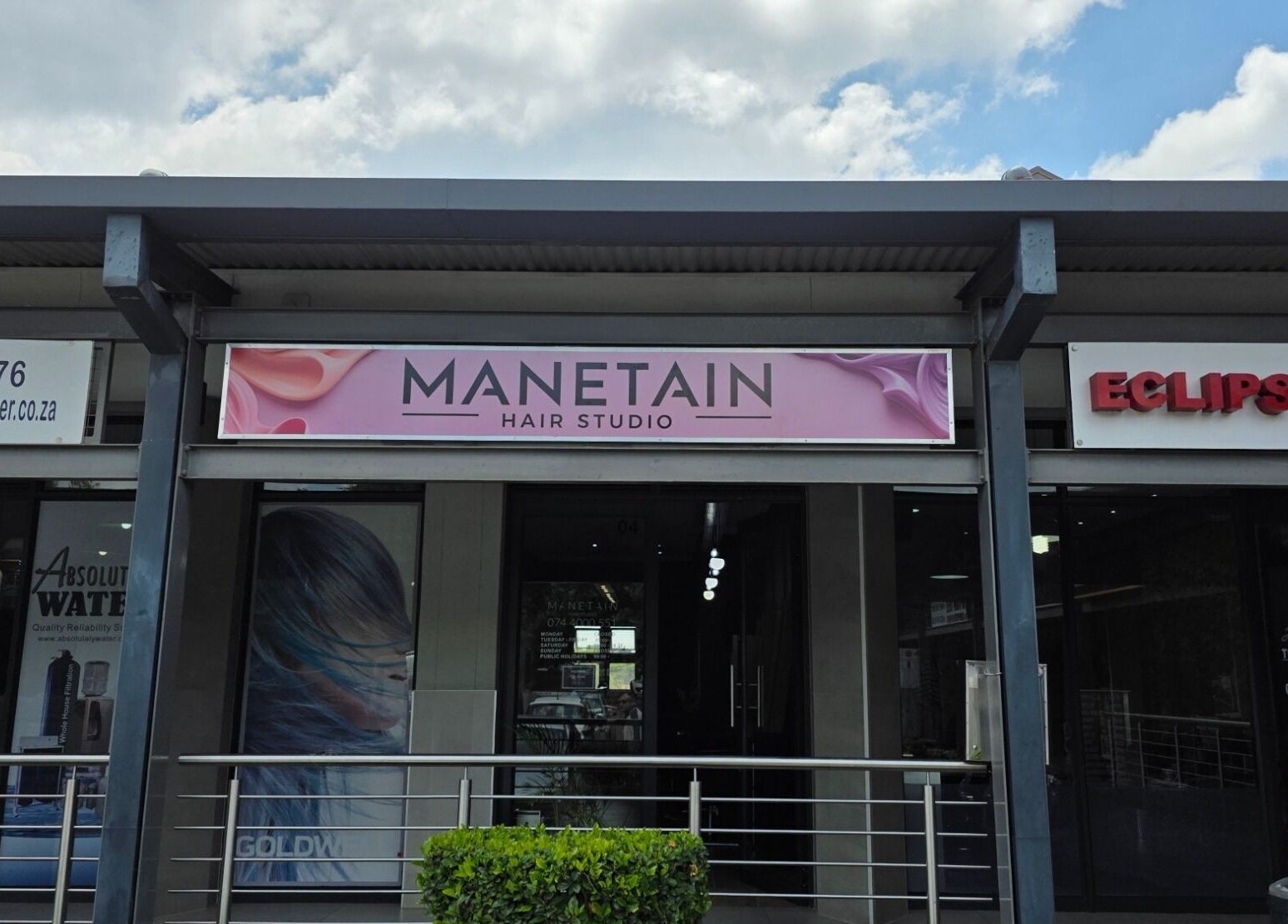 Exterior of Manetain Hair Studio in Pretoria, Gauteng, ZA with stylish signage.