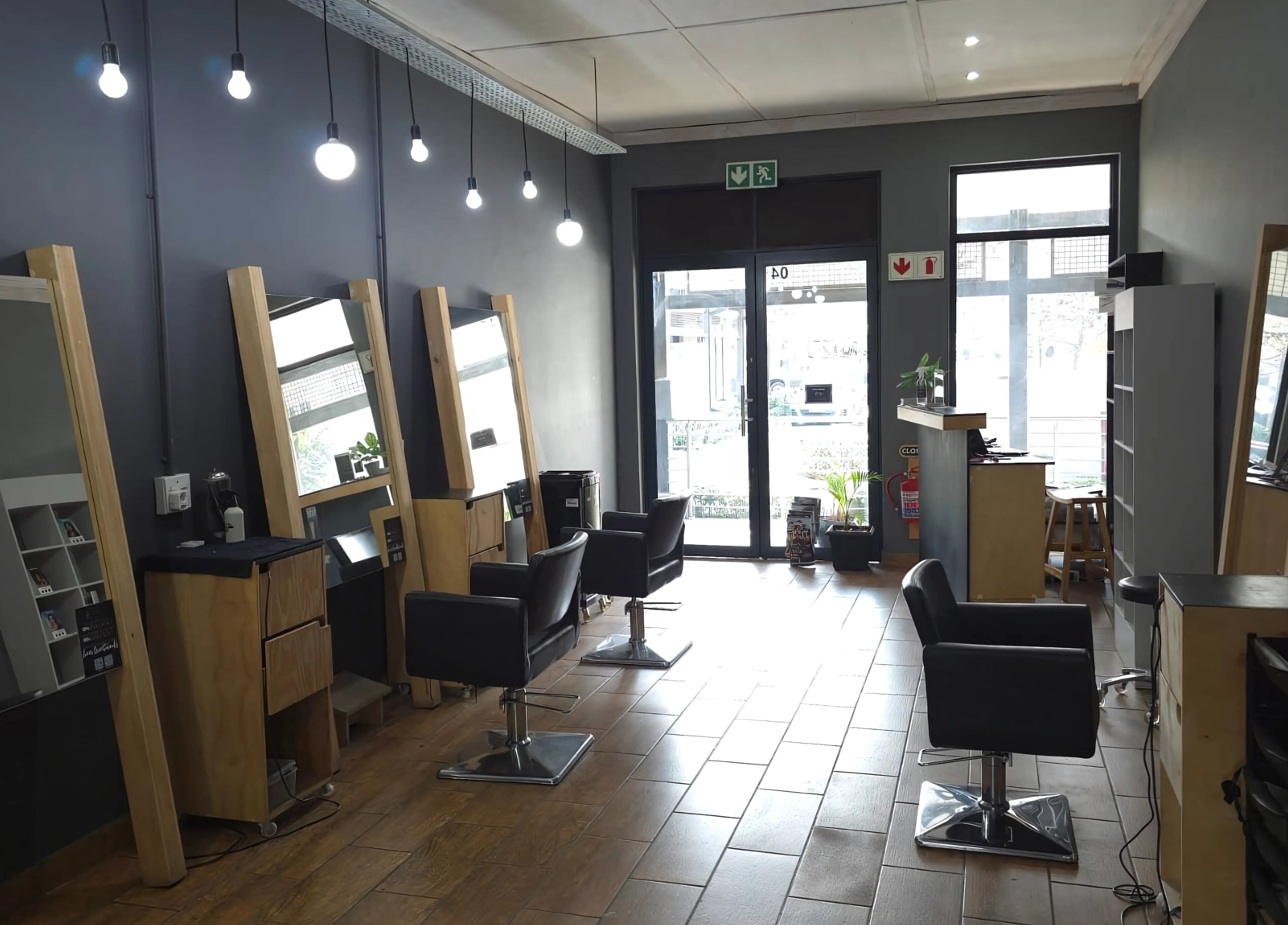 Modern salon interior at Manetain, Pretoria, Gauteng, ZA, featuring sleek styling chairs and mirrors.