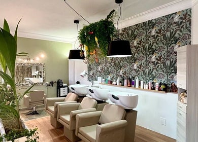 Interno lussuoso di ID Parrucchieri a Capannoli, Toscana, IT, con poltrone e decorazioni plant-based.