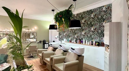 Interno lussuoso di ID Parrucchieri a Capannoli, Toscana, IT, con poltrone e decorazioni plant-based.