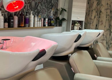 Postazioni lavaggio moderne a ID Parrucchieri, Capannoli, Toscana, IT, con luci rosse rilassanti.